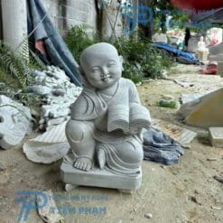Tượng Chú Tiểu chống cằm đọc sách bằng đá
